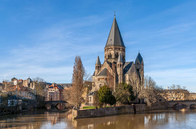 View of old building by river against sky