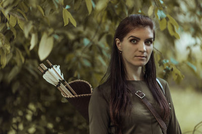 Portrait of female archer standing on field