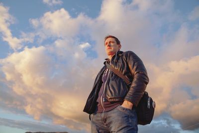 Low angle view of woman looking away against sky