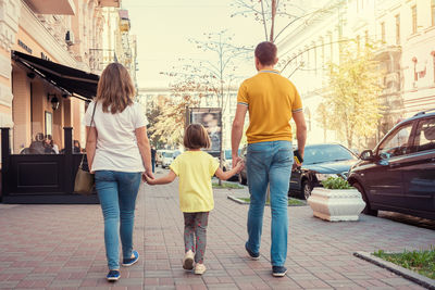 Rear view of people walking on street