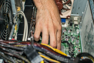 Cropped image of hand repairing mother board