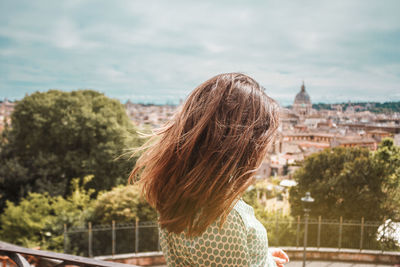 Rear view of woman standing against sky