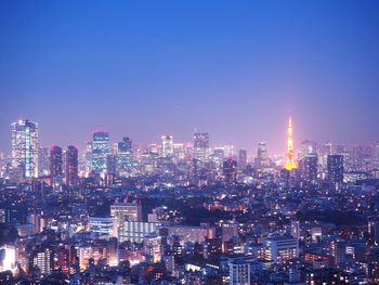 Illuminated buildings in city against sky