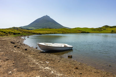 Boat on shore against clear sky