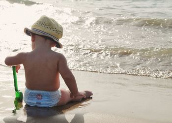 Full length of shirtless boy on beach