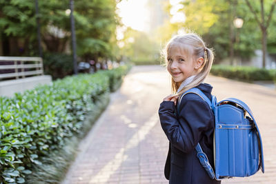 Portrait of smiling boy on footpath