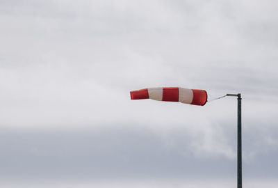 Frayed windsock in moderate wind against blue sky with copy space.