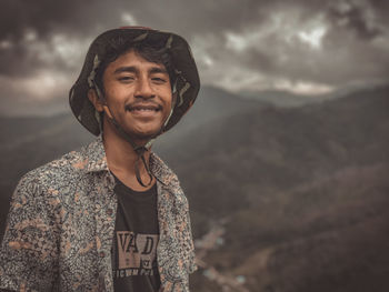Portrait of smiling man standing against sky