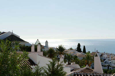 High angle view of houses by sea against sky