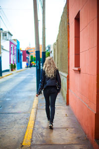 Rear view of woman walking on road