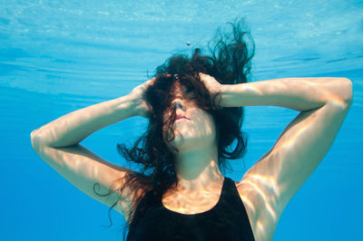 Female model swimming in pool