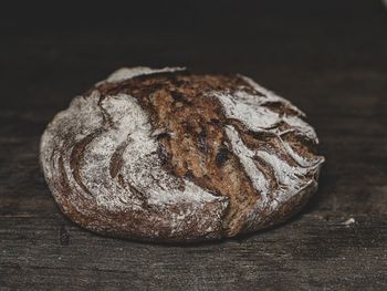 Close-up of bread on table against black background