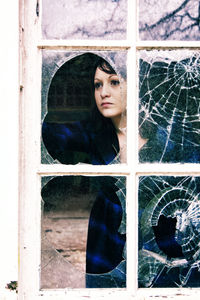 Portrait of woman looking through window