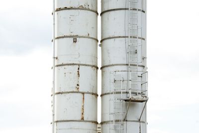 Low angle view of smoke stacks against sky