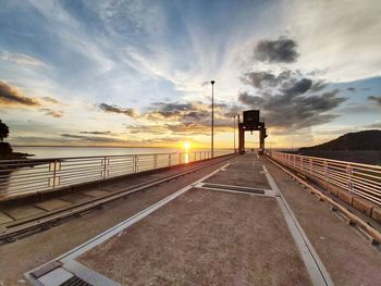 Railroad tracks against sky during sunset