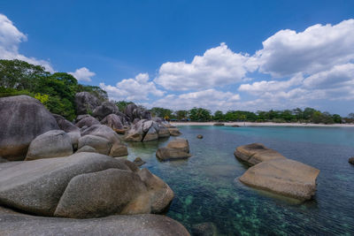 Rocks on sea shore against sky