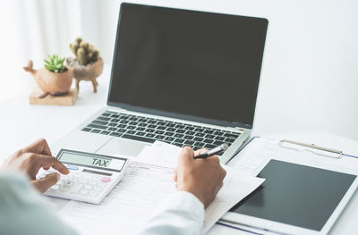 Midsection of man using laptop on table