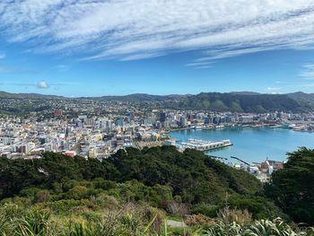 High angle view of city by sea against sky