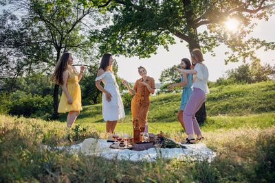 Summer party, outdoor gathering with friends. five young women, friends at the picnic dancing