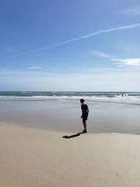 Full length of boy on beach against sky