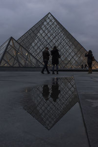 People standing on bridge against sky