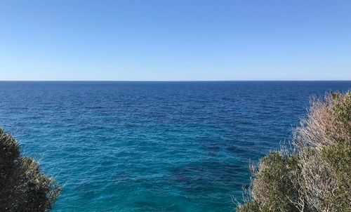 Scenic view of sea against clear blue sky