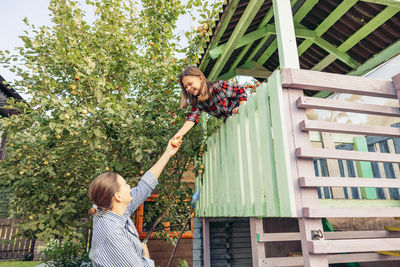 Rear view of woman standing by railing
