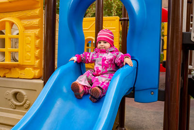 Full length of girl sitting at playground