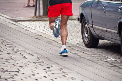 Low section of athlete running marathon on street