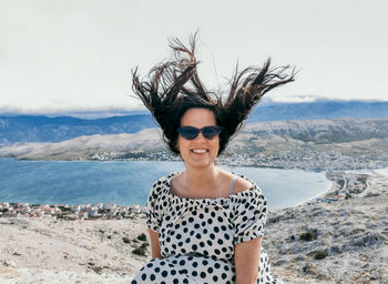 Portrait of young woman, wind blowing in her hair, funny, summer.