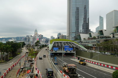 Vehicles on road in city against sky