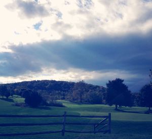 Scenic view of field against cloudy sky