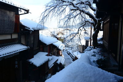 Snow covered houses and buildings against sky