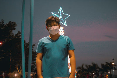 Portrait of young man standing against sky