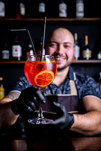 Portrait of smiling man holding drink in glass