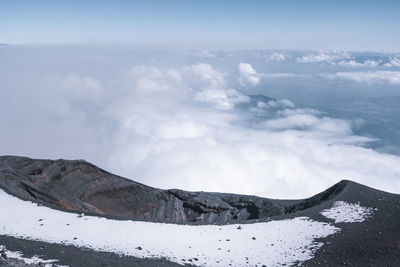 Scenic view of volcanic crater with snow against sky