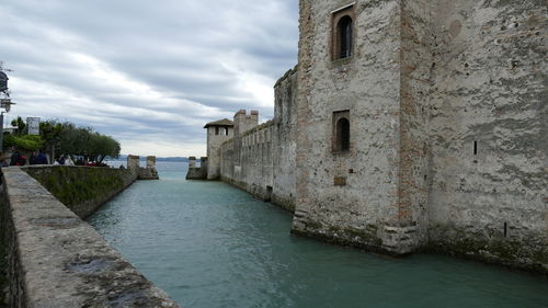 Buildings by sea against sky in city