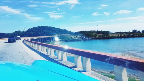 Swimming pool by sea against blue sky