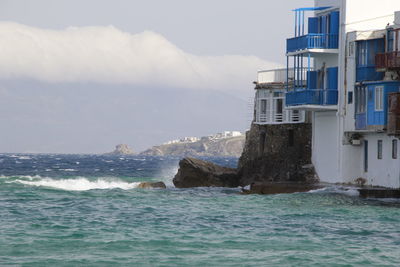 View of buildings by sea against sky