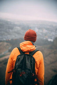 Rear view of man looking at camera against sky