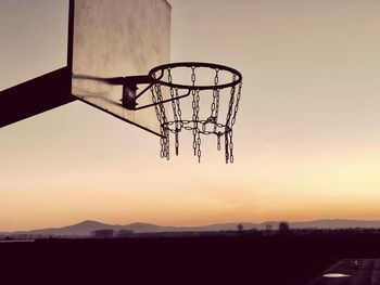 Silhouette basketball hoop against sky during sunset