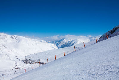 Scenic view of snowcapped mountains against blue sky