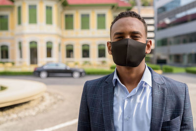 Portrait of young man standing in city