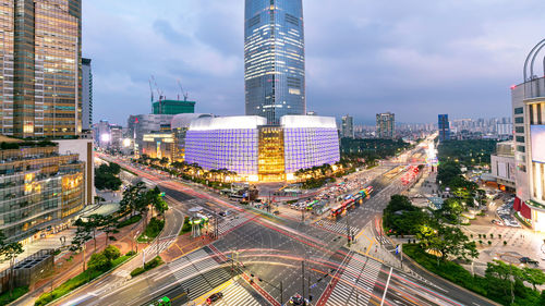 High angle view of illuminated city street and buildings against sky