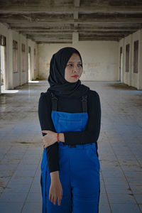 Portrait of woman standing against building