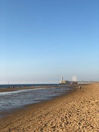 Scenic view of beach against clear blue sky