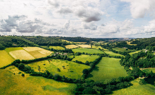 Scenic view of agricultural field against cloudy sky