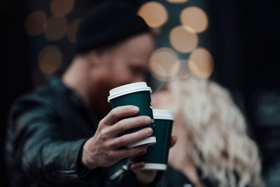 Midsection of woman holding coffee cup