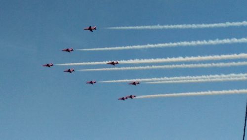 Low angle view of airplane flying against blue sky