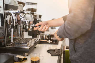 Banner of asian barista tamping the portafilter and preparing cup of coffee